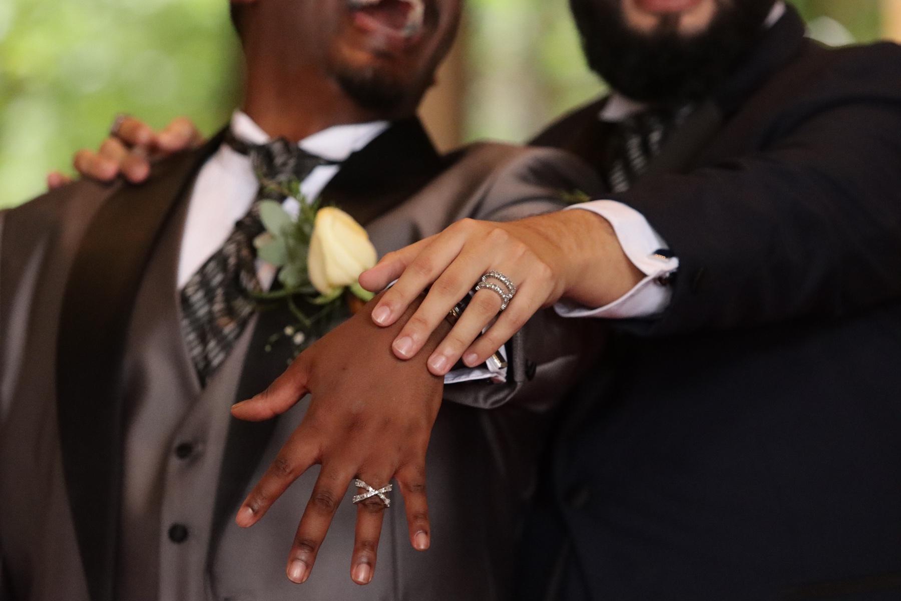 Detalle de dos manos mostrando los anillos de boda