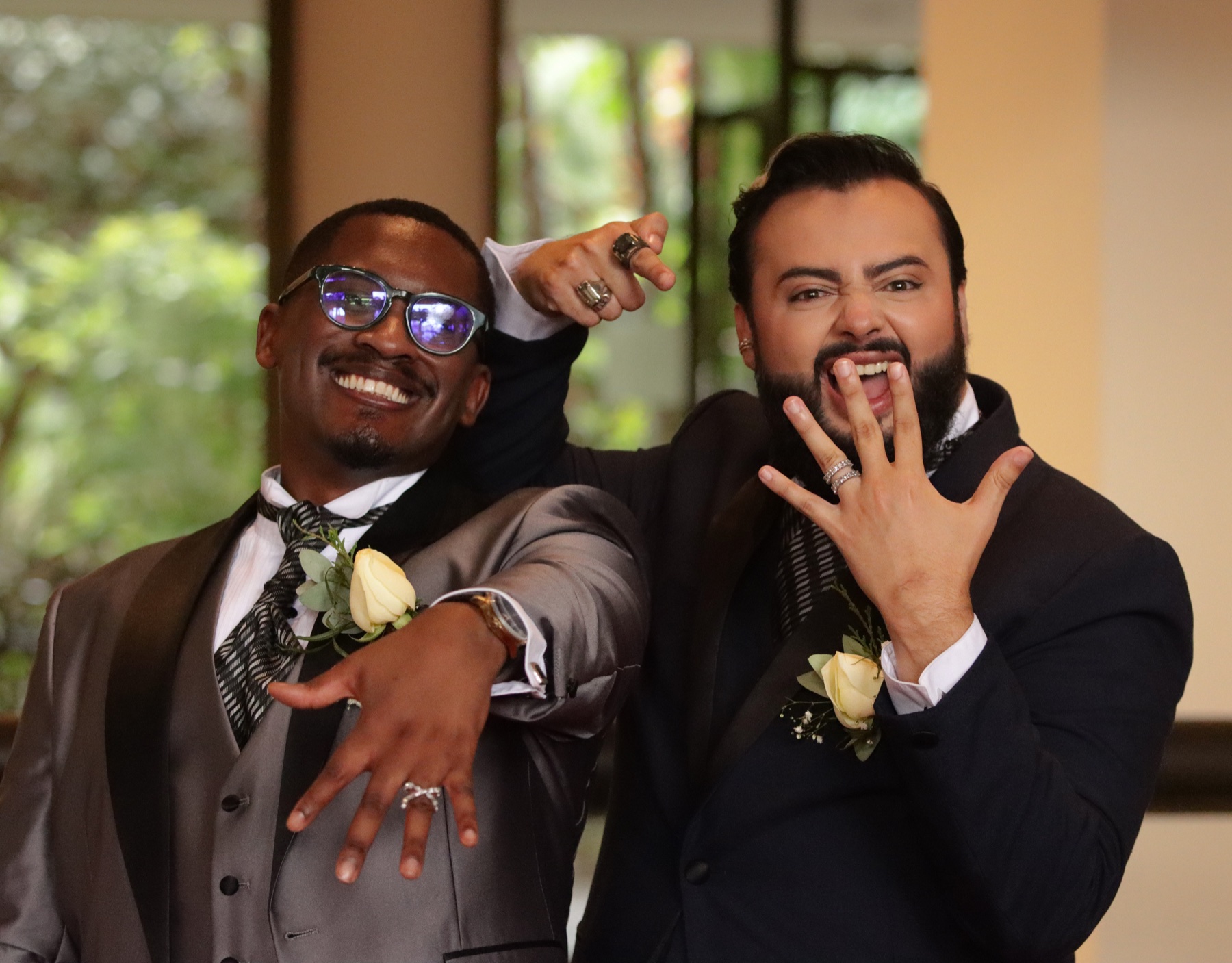 Pareja de novios celebrando y mostrando sus anillos